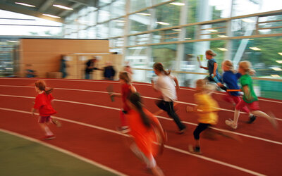 Kinderolympiade: laufende Kinder in einer Sporthalle | © Thomas Duffee / SAGA